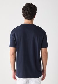T-shirt en coton bleu marine à manches courtes et col ras du cou, avec une texture lisse et un ourlet droit à la taille.