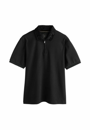 Svart pikétröja med fjärdedelsdragkedja, med en texturerad svart ormskinnstextur på kragen, korta ärmar och en avslappnad passform.