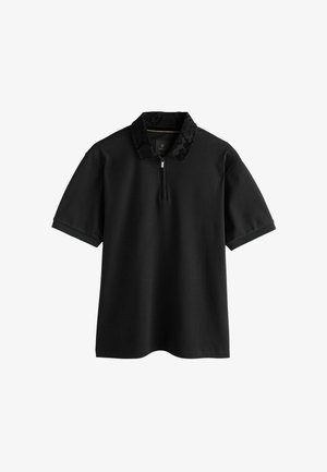 Black polo shirt with a quarter zip, featuring a textured black snake-print collar, short sleeves, and a relaxed fit.