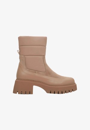 Tan enkellaarsjes met een stevige platform en gestructureerde accenten. Gemaakt van soepel leer en suede, met een gevoerde kraag en een trekband.