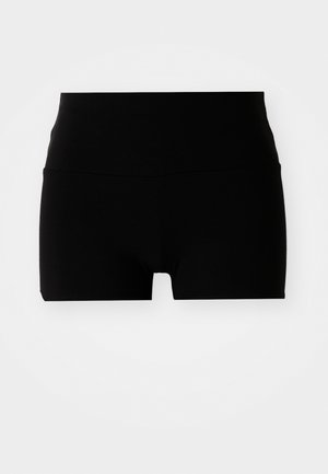 Mustad mustad madrused, millel on kõrge vöökoht, sujuva ja veniva materjaliga ning lihtne, keha järgiv disain. Ei mingeid nähtavaid mustreid ega riistvara.