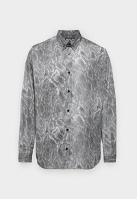 Long-sleeve shirt featuring a black and white snake print design, button-up style, and smooth fabric texture with black buttons.