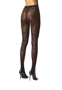 Gambe che indossano collant trasparenti neri con motivo e scarpe con tacco alto nere, mostrate da dietro su uno sfondo bianco.