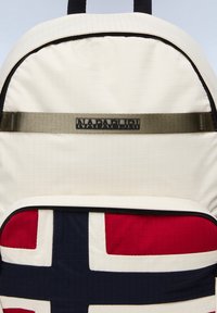Zaino color crema con tessuto testurizzato, presenta un grande motivo della bandiera norvegese in rosso, bianco e blu navy, e un pannello con logo.