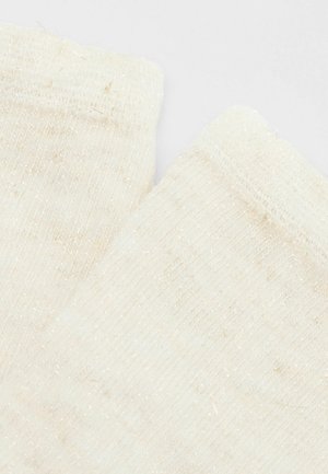 Zbliżenie na dwie jasnoszare wełniane skarpetki z prążkowanymi mankietami i subtelnymi złotymi nitkami wplecionymi w tkaninę.