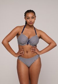 Pasiasty strój kąpielowy w kolorze granatowym i białym. Posiada projekt na sznurek na szyi, usztywnione miseczki oraz niskie majtki kąpielowe z dopasowanym wzorem.