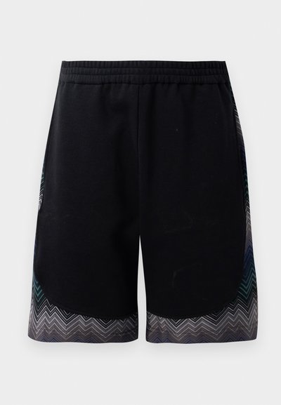 Czarne sportowe spodenki z elastycznym paskiem w talii oraz hemem w zygzaku w kolorze turkusowym, szarym i czarnym. Materiał wydaje się miękki i lekki.