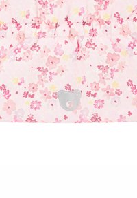 Blumenmusterstoff in rosa- und gelbtönen mit einem silbernen Bärenemblem in der Mitte. Geraffte Nähte entlang der Oberkante verleihen Textur.