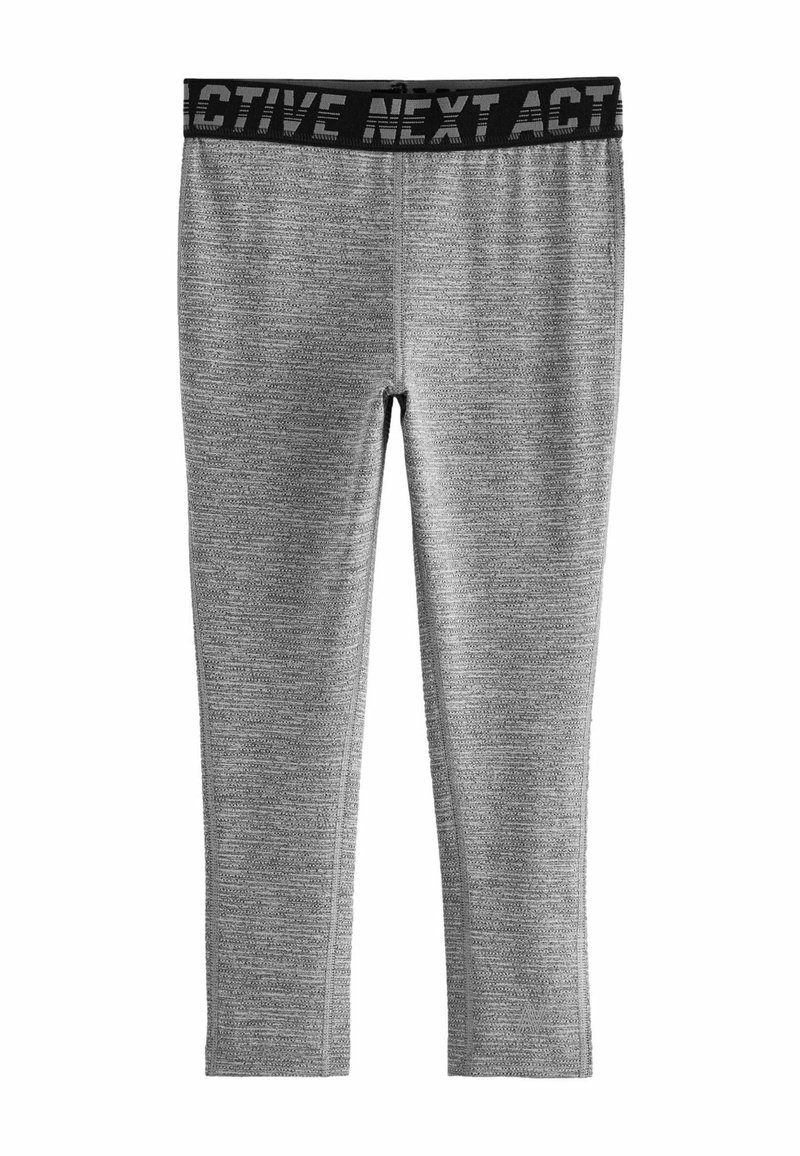 Grå aktive leggings med struktureret stof, tætsiddende design og en sort elastisk talje med "ACTIVE NEXT" i fede bogstaver.