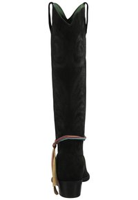 Botas altas de ante negras con un patrón texturizado en espiral, tacón bajo y detalle de cinta multicolor alrededor del tobillo. Forro interior verde.