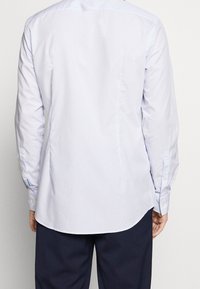  Lichtblauwe langwerpige shirt met een gladde textuur, knoopmanchetten en een gebogen zoom. Voorzien van verticale strepen en een klassieke kraag.