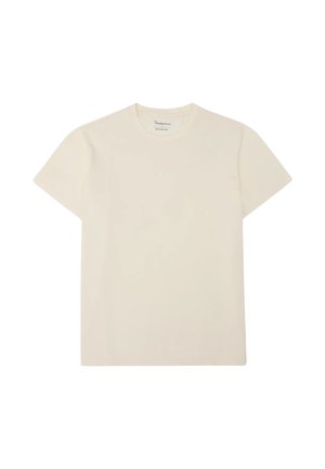 Beige T-shirt met korte mouwen en ronde hals, met minimalistische witte logotekst gecentreerd op de borst, plat weergegeven op een witte achtergrond.