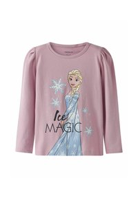 Chemise à manches longues rose clair avec un graphique représentant un personnage aux cheveux blonds portant une robe bleue, ornée de flocons de neige et du texte "Magie de Glace".