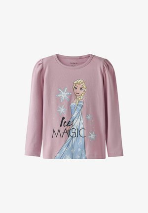 Lyserød langærmet skjorte med et grafisk motiv af en karakter med blond hår og en blå kjole, udsmykket med snefnug og teksten "Ice Magic".