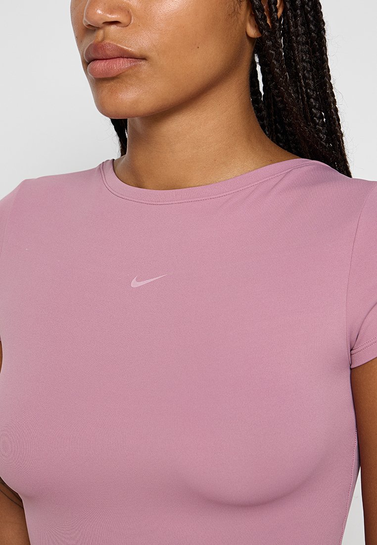 T-shirt sportivo rosa con maniche corte e scollo rotondo. Presenta un logo Nike sottile di una tonalità più chiara sul petto. Texture liscia.