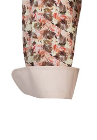 Blusa a fiori in tonalità pastello con base crema. Presenta un polsino beige chiaro, una texture liscia e un tessuto fluido progettato per il comfort.