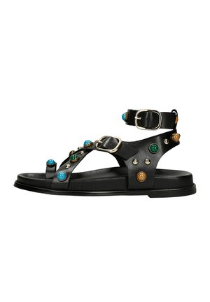 Czarna płaska sandałka z paskiem wokół kostki, srebrnymi klamrami oraz niebieskimi, zielonymi i brązowymi ozdobnymi ćwiekami na kilku paskach.