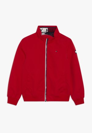 Rød lynlåstrøje med høj krave, lille logo på brystet, stribet logopatch på venstre ærme, og ribstrikkede manchetter og kant.