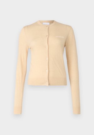 Beige cardigan laget av mykt materiale, med rund hals, knappelukking foran, og ribbestrikkede mansjetter og kant. Lite logo på brystet.