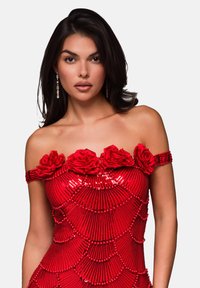 Rotes Paillettenkleid mit schulterfreien Ärmeln, ausgestattet mit drei Stoffrosen am Ausschnitt. Strukturmuster mit perlenartigen Akzenten.