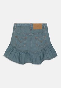 Denims kjole med flared volangkant. Lys blå farge, med to baklommer med kontrasterende søm og en brun etikett i livet.