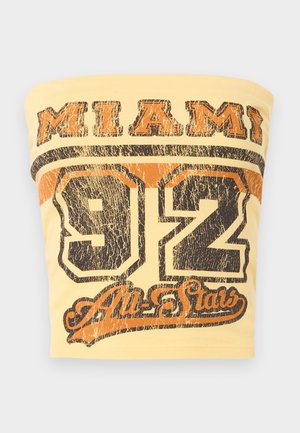 Keltainen hihaton toppi, jossa lukee "MIAMI" paksulla mustalla tekstillä ja alla on numero "92" kuluneella mustalla ja oranssilla painatuksella.