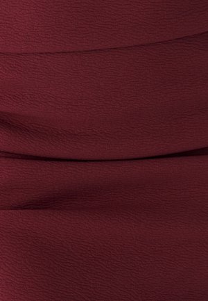 Tessuto borgogna con una leggera trama a onde, che presenta un materiale morbido ed elasticizzato che cade senza sforzo.