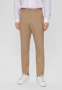 Tan trousers with a straight cut, featuring a single button closure, belt loops, and standard pockets, paired with white sneakers.
