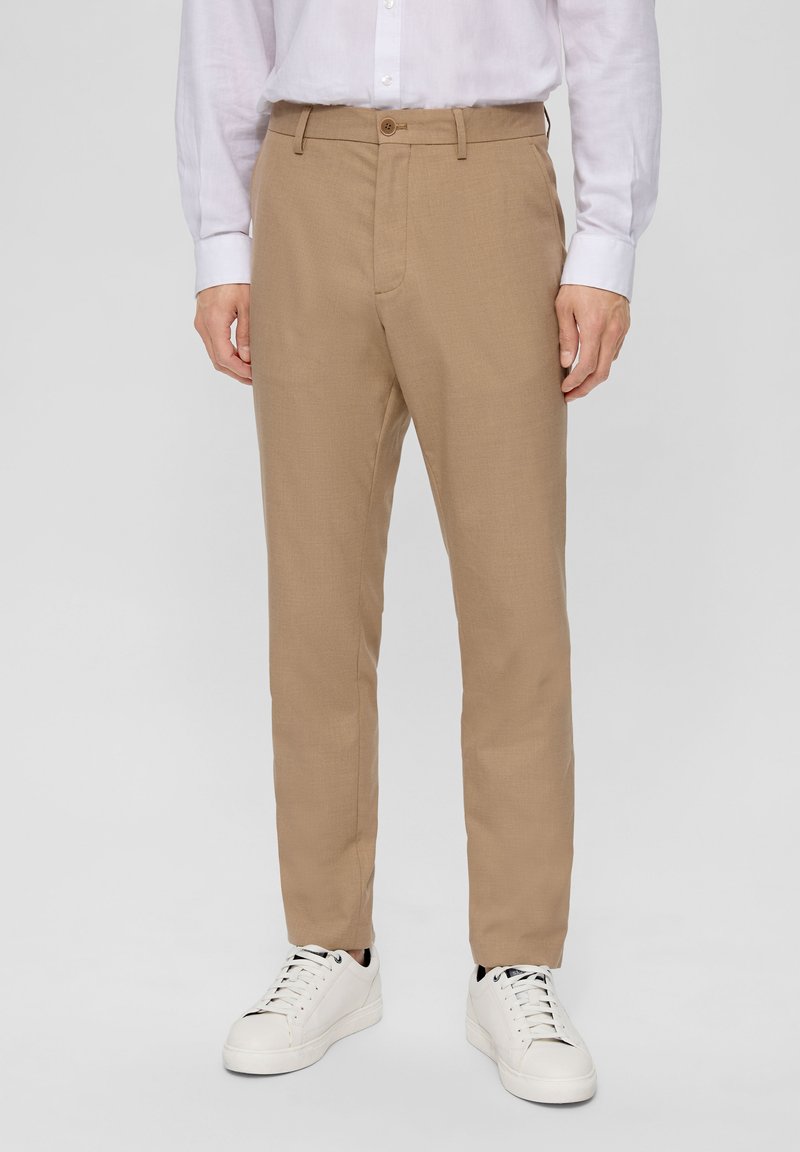 Tan trousers with a straight cut, featuring a single button closure, belt loops, and standard pockets, paired with white sneakers.