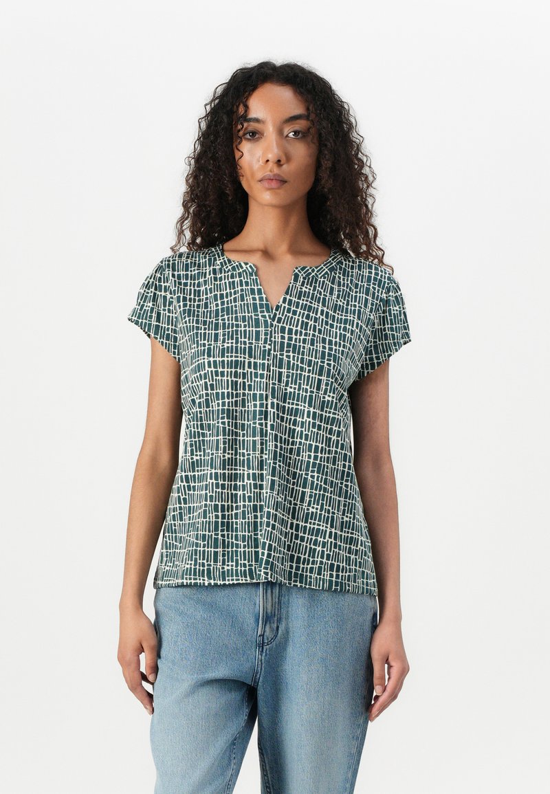 Groene blouse met korte mouwen en V-hals, met een ruitpatroon in het wit. Lichtgewicht stof met een relaxte pasvorm, gecombineerd met denim jeans.