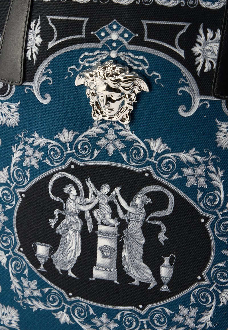 Sac fourre-tout avec un design bleu et noir, orné de ferrures Méduse en argent, de motifs argentés complexes et de figures classiques détaillées.