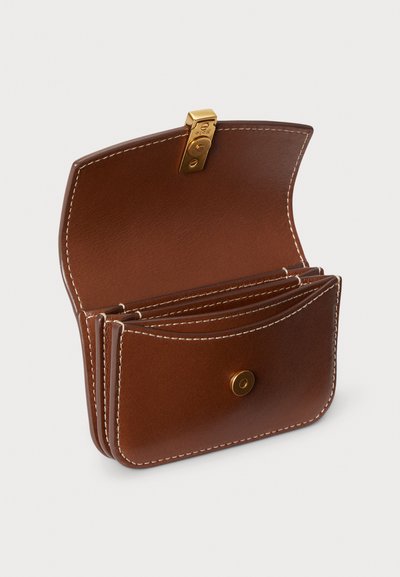 Rjava usnjena denarnica z zlatim zaponkom, z več režami za kartice in belim šivom ob robovih. Gladka tekstura z zaobljenimi robovi.