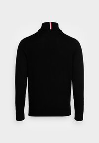 Zwarte gebreide trui met een hoge kraag, voorzien van een rood-witte gestreepte accent aan de achterkant. Lange mouwen en een effen kleur ontwerp.