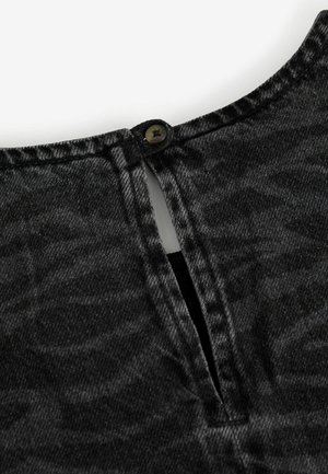 Top din denim negru, cu închidere pe spate cu buton, o mică fanta și o suprafață ușor texturată. Țesătura are un aspect estompat, uzat.