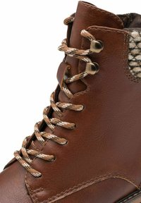 Botte en cuir marron avec une surface texturée, doublure en tissage, lacets ronds marron et beige, et œillets en métal pour le soutien des lacets.