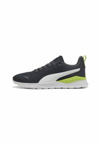 Baskets Puma pour hommes avec un dessus en maille gris foncé respirante, des accents blancs et un détail de talon texturé vert fluo sur une semelle blanche.