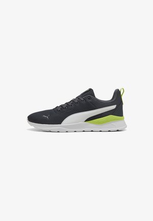 Baskets Puma pour hommes avec un dessus en maille gris foncé respirante, des accents blancs et un détail de talon texturé vert fluo sur une semelle blanche.