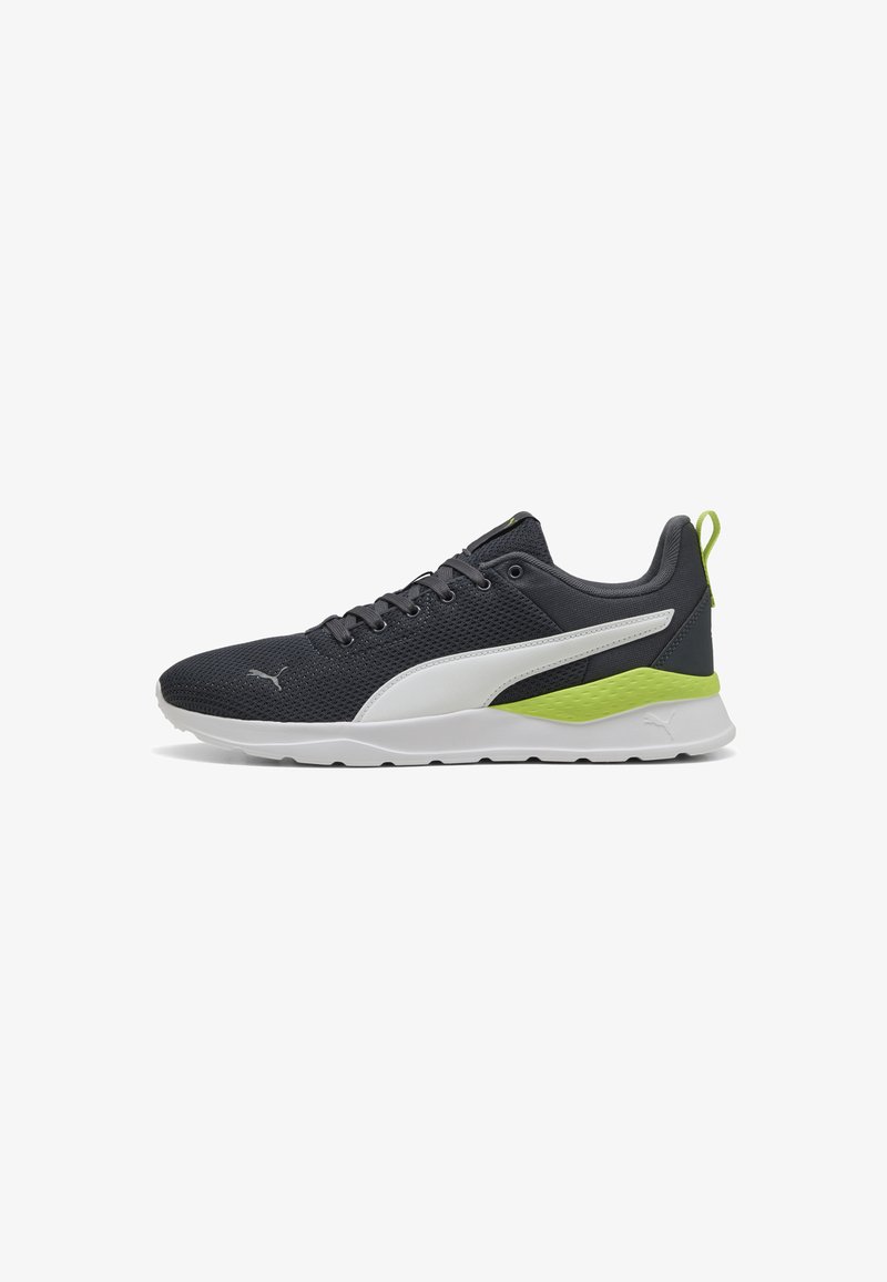 Baskets Puma pour hommes avec un dessus en maille gris foncé respirante, des accents blancs et un détail de talon texturé vert fluo sur une semelle blanche.