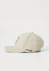 Căciulă de baseball bej cu o bordură curbată. Prezintă un patch cu logo pe față și branding "Columbia" pe lateral. Fabricată dintr-un material moale.