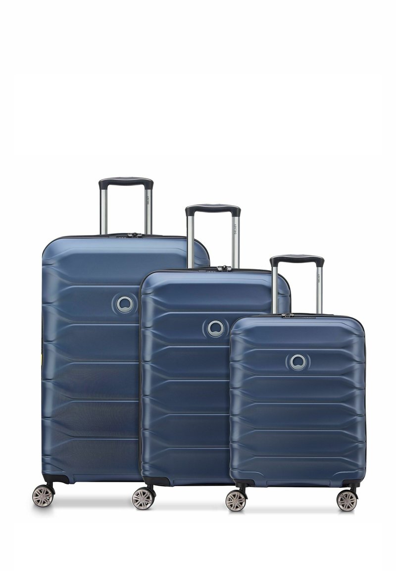 Drei marineblaue Hartschalenkoffer mit einem geriffelten Design, metallenen Teleskopgriffen und vier drehbaren Rädern für eine einfache Mobilität.