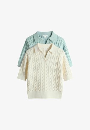 Zwei kurzärmelige Pullover mit Zopfmuster und Kragen, einer cremefarben und einer hellblau, übereinandergelegt mit dem cremefarbenen Pullover vorne.