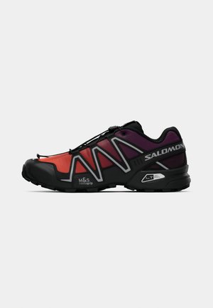 Trail running shoe in red and purple gradient with black accents, featuring a lightweight design, rubber sole, and elastic lacing system.