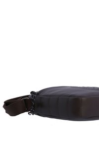 Bolso cruzado acolchado marrón con un acabado suave, correa ajustable y acentos negros. Presenta un diseño elegante y compacto para mayor practicidad.