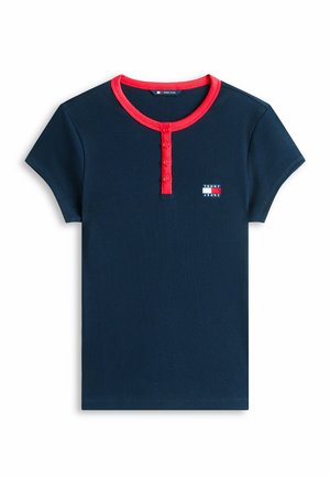 Camisa de manga corta azul marino con ribetes y botones rojos en el cuello, que presenta un pequeño logo de Tommy Jeans en el pecho.