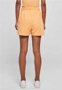 Oransje, bomullsblandede shorts med elastisk midje og en avslappet passform, med en jevn tekstur og lengde til midten av låret.