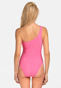 Jednoczęściowy różowy kostium kąpielowy na jedno ramię z teksturowanym wzorem, dopasowanym krojem i średnio wykrojonymi nogawkami. Szczegóły szwów wzdłuż dekoltu.