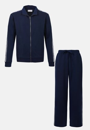 Chándal azul marino que incluye una chaqueta con cremallera y cuello alzado, con rayas blancas en los laterales, acompañado de pantalones con cordón en la cintura. Tejido suave, corte relajado.