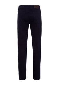 Jean slim fit bleu marine foncé vu de dos avec poches arrière, passants de ceinture et un patch en cuir marron sur la taille.