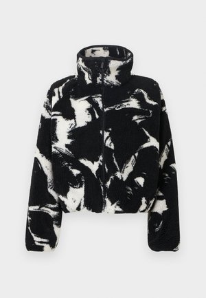 Lühendatud fliisjakk, millel on musta ja valge abstraktse mustriga, kõrge krae ja esikäe tõmblukk, tekstuurse, pehme materjaliga.