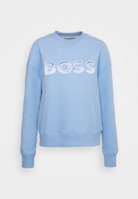 Ljusblå sweatshirt i bomull, med rund hals, sänkta axlar och fet vit "BOSS"-logotyp i texturerad detalj på bröstet.